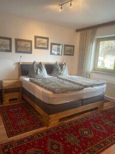 Cozy bedroom with modern bed, pictures, and carpet in Pension Bohemia.
