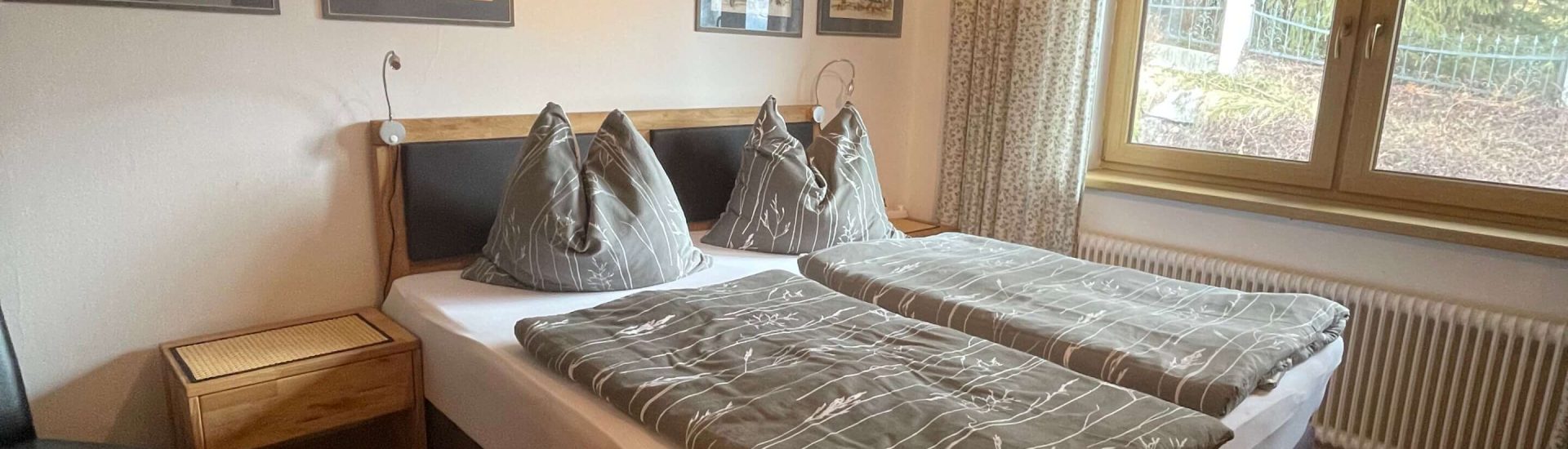 Gemütliches Schlafzimmer mit Doppelbett, Bildern und Teppich im modernen Stil.